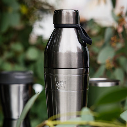 Nitro insulated KeepCup water bottle with silver lid on a blurred natural background