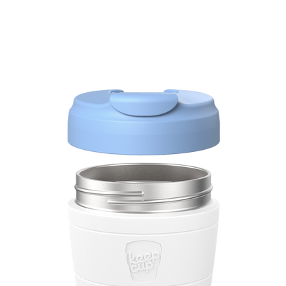 KeepCup Commuter Flip Lid in Orchid shown lifted above a white reusable cup with stainless steel rim, displaying how the light blue lid attaches to the cup body.