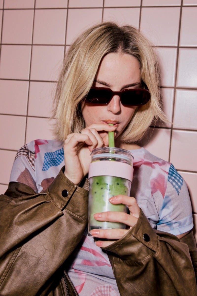 Woman holding KeepCup Longplay Pashmak Pink 16oz with iced matcha