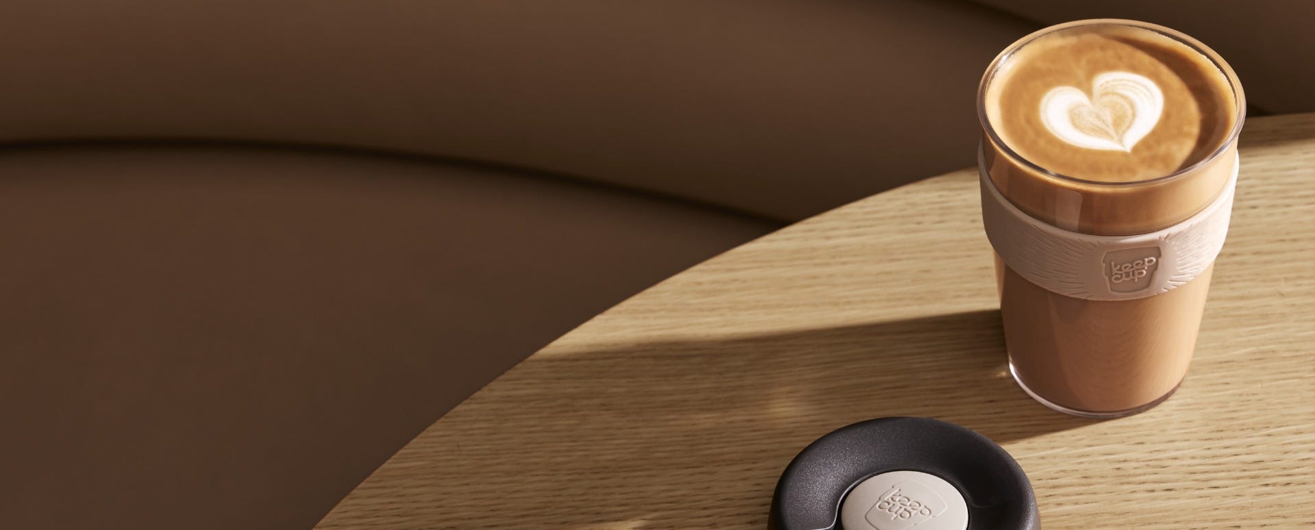 KeepCup Original Clear M 12oz sitting on table with coffee